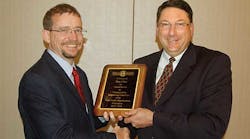 Kentucky Trailer&rsquo;s George Gauntt, left presents a plaque to Dan Giles, Fontaine Trailer, for serving as chairman of the TTMA Engineering Committee.