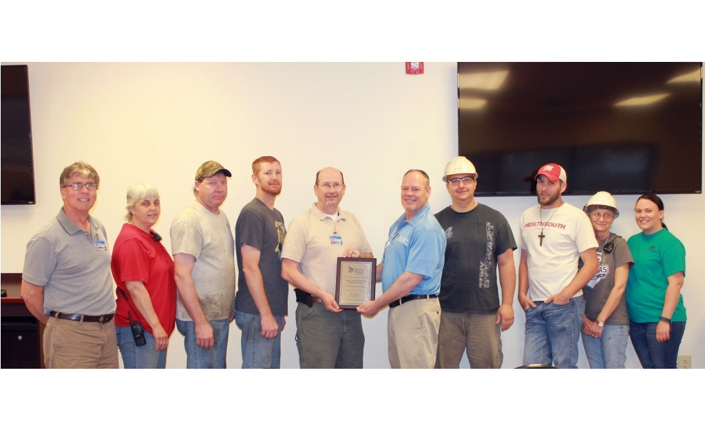 Dale Innis of Liberty Mutual Insurance Risk Control Services presents the Safety Award to a group of UTM39s Paragould AR plant employees representing the plant