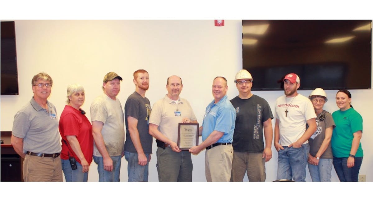 Dale Innis of Liberty Mutual Insurance, Risk Control Services, presents the Safety Award to a group of UTM&apos;s Paragould, AR plant employees representing the plant.