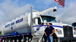 Josh Long, White Oak Mills transportation manager, stands beside a Kenworth T880S 7-axle configuration with 26-foot Walinga feed body.