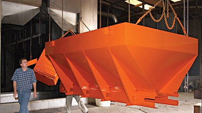 A Vbox spreader exits the cure oven and is inspected by RD Manning former owner of Good Roads