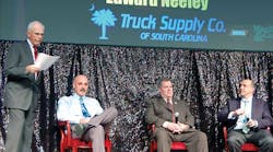 Stu MacKay, president of MacKay &amp; Company asks a question of his panel of distributors: Mike McKay, director of parts operations for Kenworth Sales Company; Edward Neeley, owner of Truck Supply Company; and Geoff Garafola, vice-president of Inland Truck Parts.