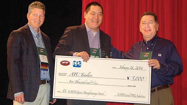 Lucas Landis marketing director for ATC Trailers receives the NATM Green Award from Mike Lloyd NATM president and Ron Yarnell PPG The 5000 award sponsored by PPG goes to the winning companyrsquos favorite charity