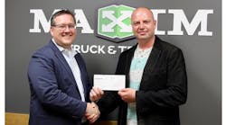 Troy Hamilton (left), president of Maxim Truck &amp; Trailer, presents Charles Roberts, executive director of Live Different, with a check representing $150,000 of support for Live Different&rsquo;s work with indigenous communities in Canada.
