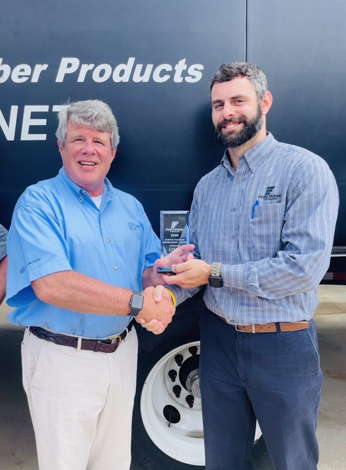 OHC President Lee Robinson Jr., left, accepts the Supply Partner Excellence Award from Jamie Hendricks, GM of Fontaine Trailer.
