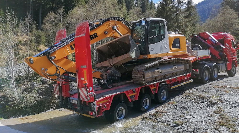 A Goldhofer Liebherr R918 crawler excavator is transported to a remote Austrian gorge by a 3-axle semi lowloader.