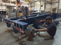 Pratt Industries workers install axles on its assembly line.