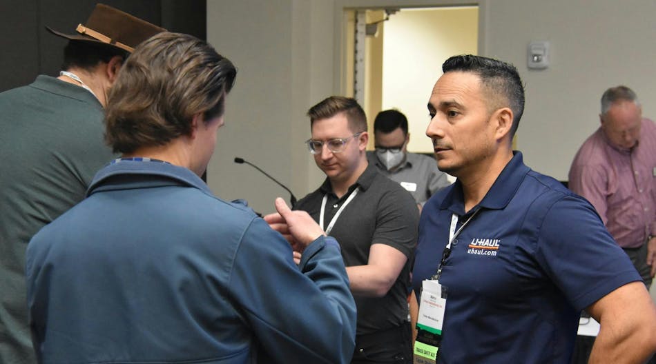 2023 NATM President Marco Garcia, director of engineering services at U-Haul International, speaks to association members in the hallway outside one of the technical sessions during this year&apos;s show last February.