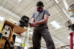 Technician advisor Joseph Ambrose grinds some flat stock to be used on a trailer's front end. Technician advisor Joseph Ambrose grinds some flat stock to be used on a trailer's front end.
