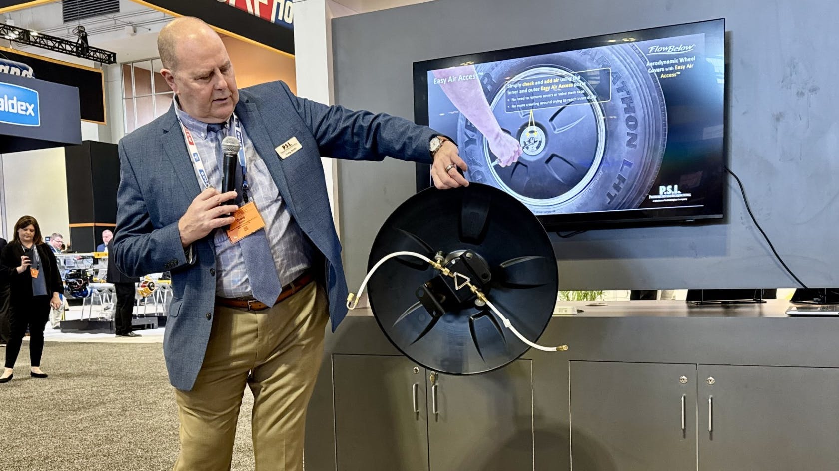 Craig Smith, VP of marketing and communications for P.S.I., demonstrates the new aerodynamic wheel cover with integrated Easy Air Access.